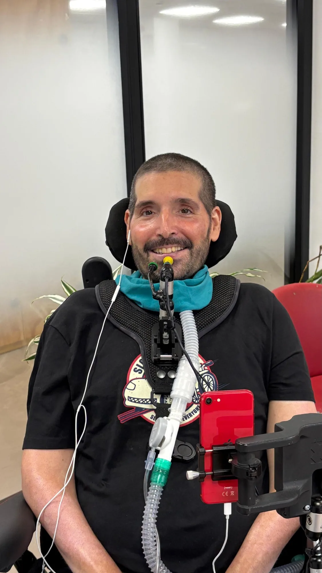 Armando Folgado sonriendo con su dispositivo de comunicación